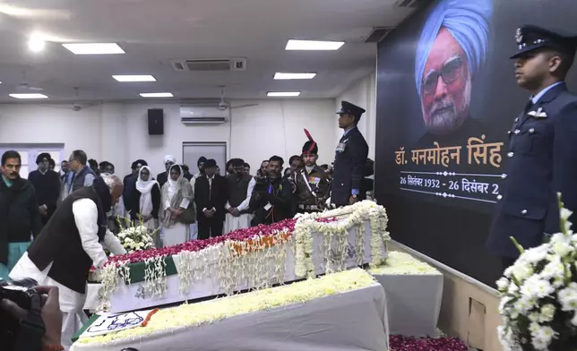 Congress party President Mallikarjun Kharge touches the casket of former Indian Prime Minister Manmohan Singh to pay his tributes at the party headquarters in New Delhi, India, Saturday, Dec. 28, 2024. (AP Photo)