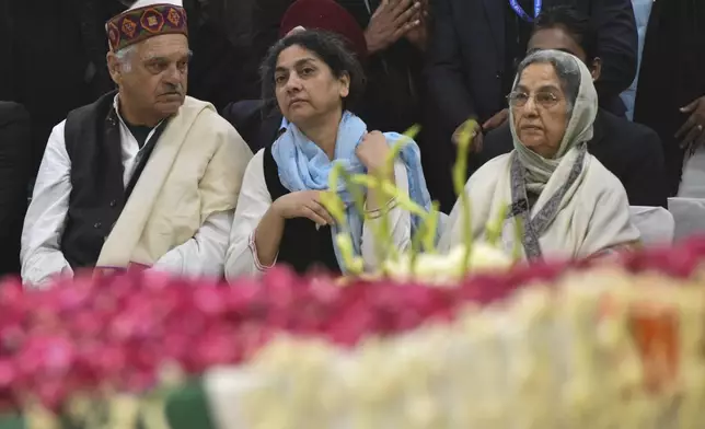 Gursharan Kaur, right, wife of former Indian Prime Minister Manmohan Singh, sits with others next to the casket of her late husband at Congress party headquarters in New Delhi, India, Saturday, Dec. 28, 2024. (AP Photo)