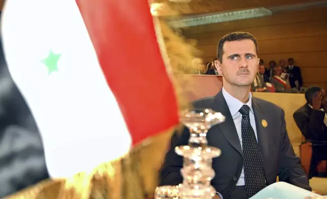 FILE - Syrian President Bashar Assad looks on at his country's flag at the opening of the 16th ordinary session of Arab Summit in Tunis, May 22, 2004. (AP Photo/Amr Nabil, File)