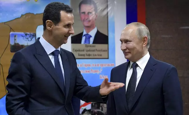 FILE - Syrian President Bashar Assad, left, gestures while speaking to Russian President Vladimir Putin during their meeting in Damascus, Syria, Jan. 7, 2020. (Alexei Druzhinin, Sputnik, Kremlin Pool Photo via AP, File)