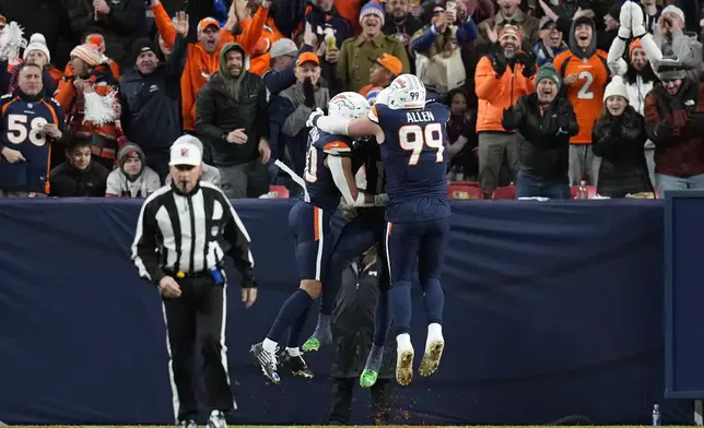 Denver Broncos linebacker Justin Strnad, left, linebacker Nik Bonitto, center, and defensive end Zach Allen (99) celebrate the 71-yard interception for a touchdown by Bonitto during the first half of an NFL football game against the Cleveland Browns, Monday, Dec. 2, 2024, in Denver. (AP Photo/Jack Dempsey)