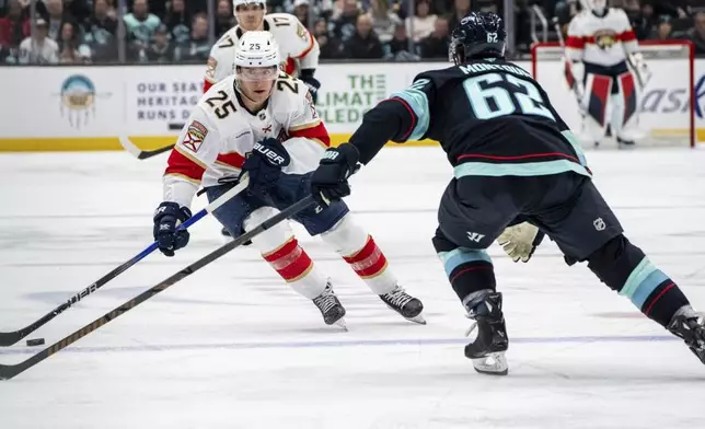 Florida Panthers forward Mackie Samoskevich, left, skates against Seattle Kraken defenseman Brandon Montour during the third period of an NHL hockey game, Tuesday, Dec. 10, 2024, in Seattle. The Panthers won 2-1 in a shootout. (AP Photo/Stephen Brashear)