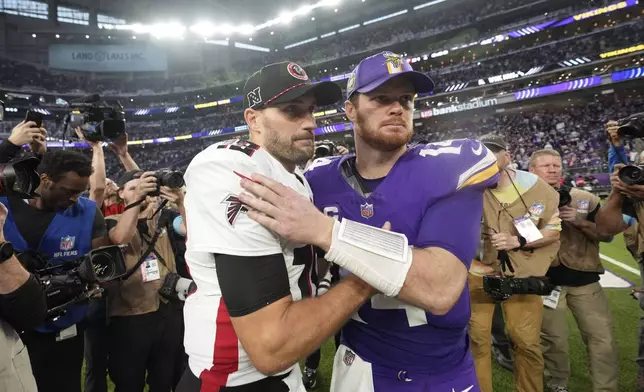 Atlanta Falcons quarterback Kirk Cousins, left, talks with Minnesota Vikings quarterback Sam Darnold after an NFL football game, Sunday, Dec. 8, 2024, in Minneapolis. (AP Photo/Abbie Parr)