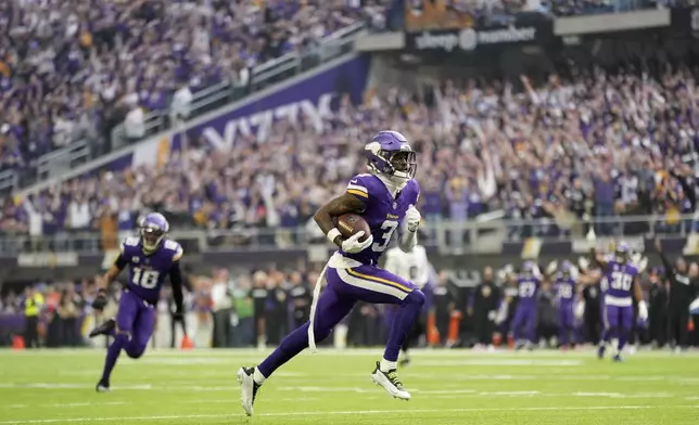 Minnesota Vikings wide receiver Jordan Addison scores on a 49-yard touchdown reception during the first half of an NFL football game against the Atlanta Falcons, Sunday, Dec. 8, 2024, in Minneapolis. (AP Photo/Abbie Parr)