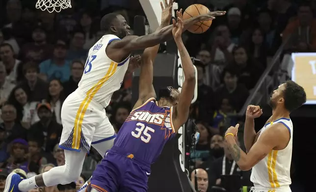 Golden State Warriors forward Draymond Green (23) blocks the shot on Phoenix Suns forward Kevin Durant during the first half of an NBA basketball game, Saturday, Nov. 30, 2024, in Phoenix. (AP Photo/Rick Scuteri)