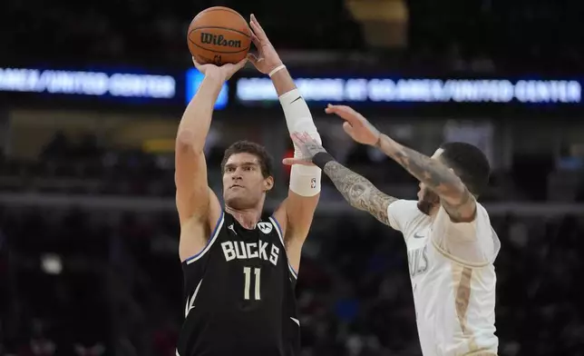 Chicago Bulls guard Lonzo Ball, right, tries to block a 3-point shot by Milwaukee Bucks center Brook Lopez (11) during the first half of an NBA basketball game Saturday, Dec. 28, 2024, in Chicago. (AP Photo/Erin Hooley)