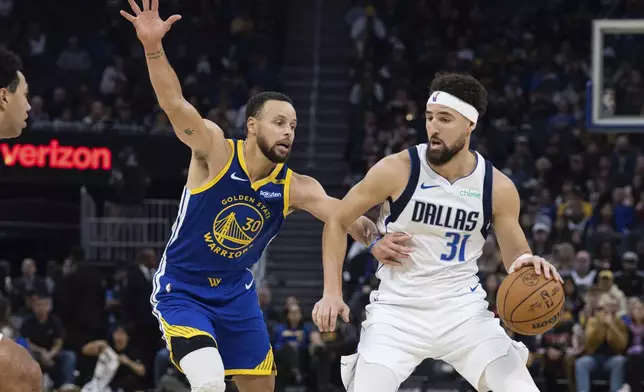 Golden State Warriors guard Stephen Curry (30) defends against Dallas Mavericks guard Klay Thompson (31) during the first half of an NBA basketball game Sunday, Dec. 15, 2024, in San Francisco. (AP Photo/Benjamin Fanjoy)