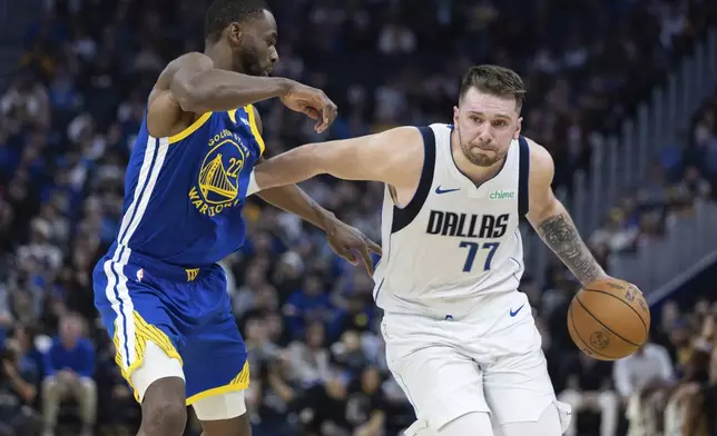 Golden State Warriors forward Andrew Wiggins (22) defends against Dallas Mavericks forward Luka Dončić (77) during the first half of an NBA basketball game Sunday, Dec. 15, 2024, in San Francisco. (AP Photo/Benjamin Fanjoy)