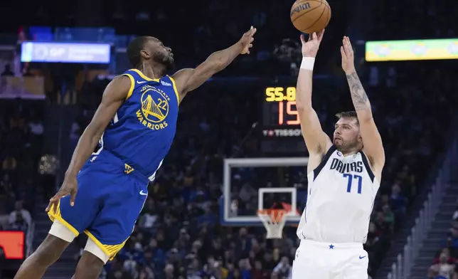 Golden State Warriors forward Andrew Wiggins (22) defends against Dallas Mavericks forward Luka Dončić (77) during the first half of an NBA basketball game Sunday, Dec. 15, 2024, in San Francisco. (AP Photo/Benjamin Fanjoy)