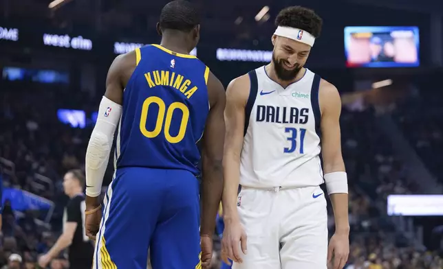 Golden State Warriors forward Jonathan Kuminga (00) stands as Dallas Mavericks guard Klay Thompson walks past during the first half of an NBA basketball game Sunday, Dec. 15, 2024, in San Francisco. (AP Photo/Benjamin Fanjoy)