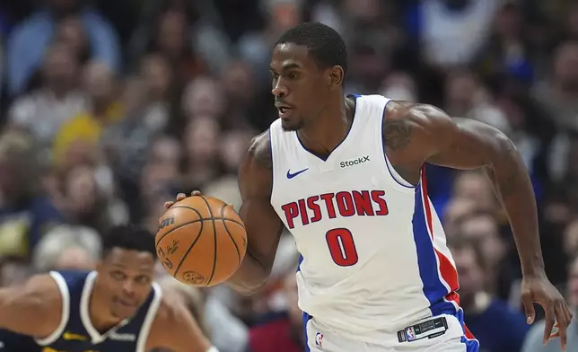 Detroit Pistons center Jalen Duren, front, picks up a loose ball as Denver Nuggets guard Russell Westbrook defends in the first half of an NBA basketball game Saturday, Dec. 28, 2024, in Denver. (AP Photo/David Zalubowski)