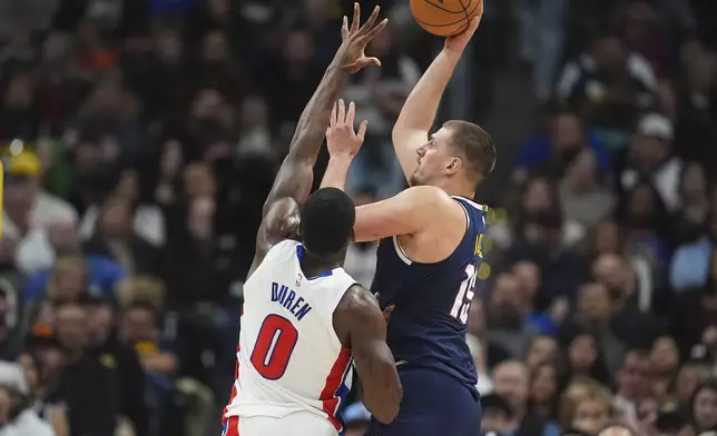 Denver Nuggets center Nikola Jokic, right, shoots for a basket as Detroit Pistons center Jalen Duren defends in the first half of an NBA basketball game Saturday, Dec. 28, 2024, in Denver. (AP Photo/David Zalubowski)