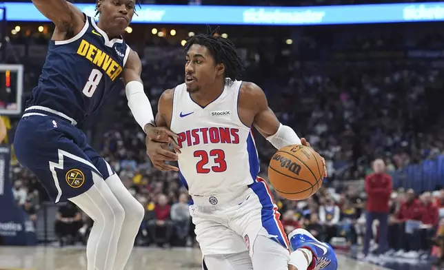 Detroit Pistons guard Jaden Ivey, right, drives to the basket as Denver Nuggets forward Peyton Watson defends in the first half of an NBA basketball game Saturday, Dec. 28, 2024, in Denver. (AP Photo/David Zalubowski)