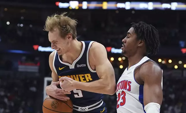 Denver Nuggets forward Hunter Tyson, left, loses control of the ball as Detroit Pistons guard Jaden Ivey defends in the first half of an NBA basketball game Saturday, Dec. 28, 2024, in Denver. (AP Photo/David Zalubowski)