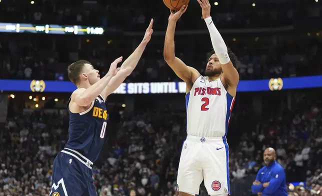 Detroit Pistons guard Cade Cunningham, right, shoots for a basket as Denver Nuggets guard Christian Braun defends in the first half of an NBA basketball game Saturday, Dec. 28, 2024, in Denver. (AP Photo/David Zalubowski)