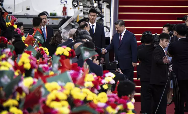 China's President Xi Jinping, center right, shakes hands with outgoing Macao Chief Executive Ho Iat-seng as he arrives at the airport in Macao, China, Wednesday, Dec. 18, 2024, ahead of celebrations marking the 25th anniversary of the casino city’s return to Chinese rule. (Eduardo Leal/Pool Photo via AP)