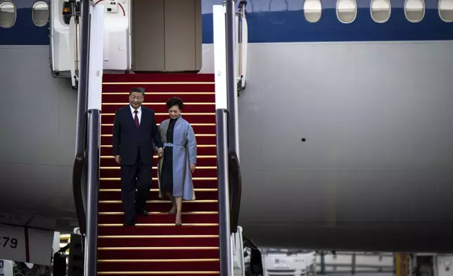 China's President Xi Jinping, left, and his wife Peng Liyuan, right, arrive at the airport in Macao, China, Wednesday, Dec. 18, 2024, ahead of celebrations marking the 25th anniversary of the casino city’s return to Chinese rule. (Eduardo Leal/Pool Photo via AP)