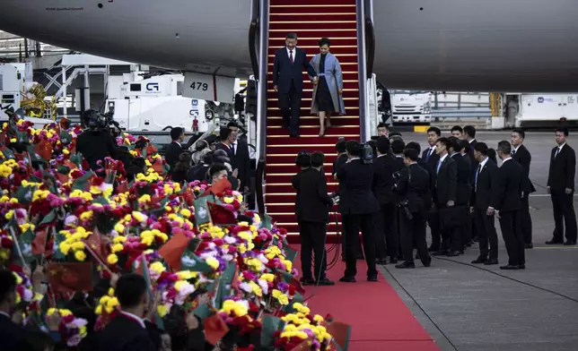 China's President Xi Jinping, center left, and his wife Peng Liyuan alight from their aircraft after arriving at the airport in Macao, China, Wednesday, Dec. 18, 2024, ahead of celebrations marking the 25th anniversary of the casino city’s return to Chinese rule. (Eduardo Leal/Pool Photo via AP)