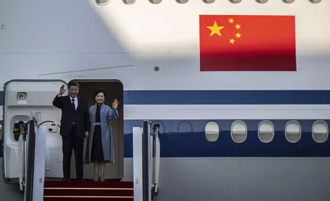 China's President Xi Jinping and his wife Peng Liyuan wave as they arrive at the airport in Macao, China, Wednesday, Dec. 18, 2024, ahead of celebrations marking the 25th anniversary of the casino city’s return to Chinese rule. (Eduardo Leal/Pool Photo via AP)