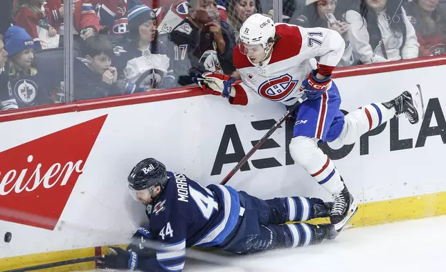 Winnipeg Jets' Josh Morrissey (44) and Montreal Canadiens' Jake Evans (71) collide during the second period of an NHL hockey game, Saturday, Dec. 14, 2024 in Winnipeg, Manitoba. (John Woods/The Canadian Press via AP)