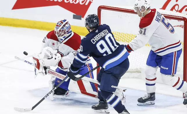 Montreal Canadiens goaltender Sam Montembeault (35) saves the deflection by Winnipeg Jets' Nikita Chibrikov (90) during the second period of an NHL hockey game, Saturday, Dec. 14, 2024 in Winnipeg, Manitoba. (John Woods/The Canadian Press via AP)