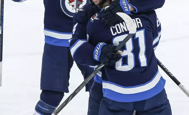 Winnipeg Jets' Josh Morrissey (44), Mark Scheifele (55) and Kyle Connor (81) celebrate Connor's goal against the Montreal Canadiens during the second period of an NHL hockey game, Saturday, Dec. 14, 2024 in Winnipeg, Manitoba. (John Woods/The Canadian Press via AP)