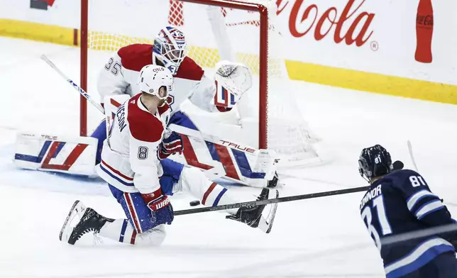 Winnipeg Jets' Kyle Connor (81) scores on Montreal Canadiens goaltender Sam Montembeault (35) as Mike Matheson (8) defends during the second period of an NHL hockey game, Saturday, Dec. 14, 2024 in Winnipeg, Manitoba. (John Woods/The Canadian Press via AP)