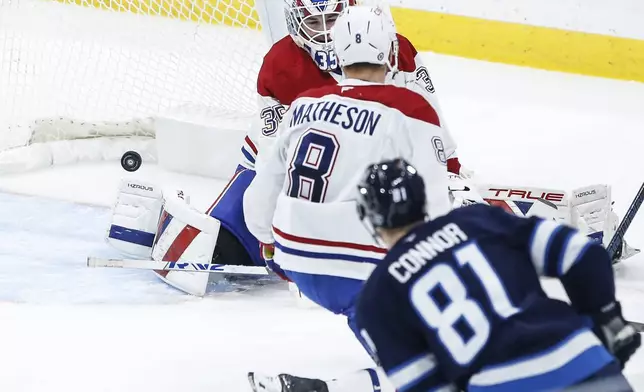 Winnipeg Jets' Kyle Connor (81) scores on Montreal Canadiens goaltender Sam Montembeault (35) as Mike Matheson (8) defends during the second period of an NHL hockey game, Saturday, Dec. 14, 2024 in Winnipeg, Manitoba. (John Woods/The Canadian Press via AP)