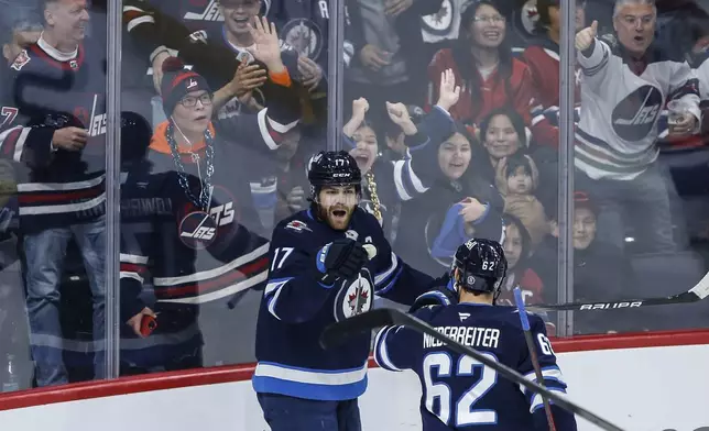 Winnipeg Jets' Adam Lowry (17) and Nino Niederreiter (62) celebrate Lowry's goal against the Montreal Canadiens during the first period of an NHL hockey game, Saturday, Dec. 14, 2024 in Winnipeg, Manitoba. (John Woods/The Canadian Press via AP)