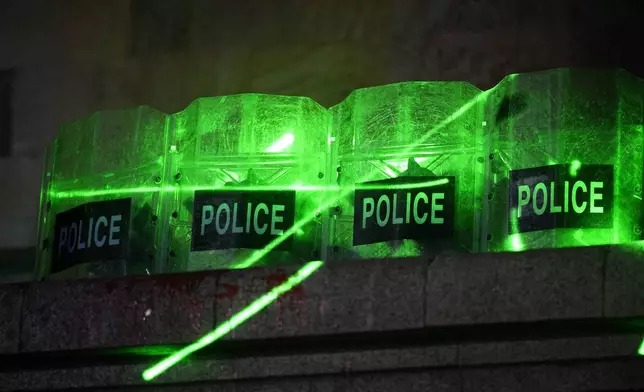 Demonstrators use laser flashlights against the police guarding the parliament's building during a rally to protest against the government's decision to suspend negotiations on joining the European Union in Tbilisi, Georgia, Tuesday, Dec. 3, 2024. (AP Photo/Pavel Bednyakov)