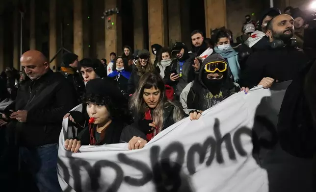 Demonstrators gather to continue protest against the government's decision to suspend negotiations on joining the European Union outside the parliament's building in Tbilisi, Georgia, on Tuesday, Dec. 3, 2024. (AP Photo/Pavel Bednyakov)