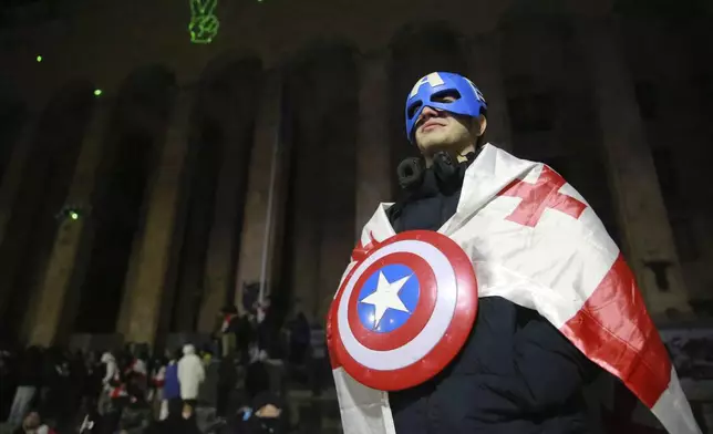 A demonstrator attends a rally outside the parliament's building to protests against the government's decision to suspend negotiations on joining the European Union in Tbilisi, Georgia, on Tuesday, Dec. 3, 2024. (AP Photo/Zurab Tsertsvadze)