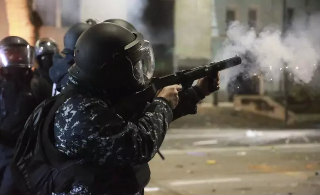 A police officer launches tear gas towards protesters rallying against the government's decision to suspend negotiations on joining the European Union in Tbilisi, Georgia, early Tuesday, Dec. 3, 2024. (AP Photo/Zurab Tsertsvadze)