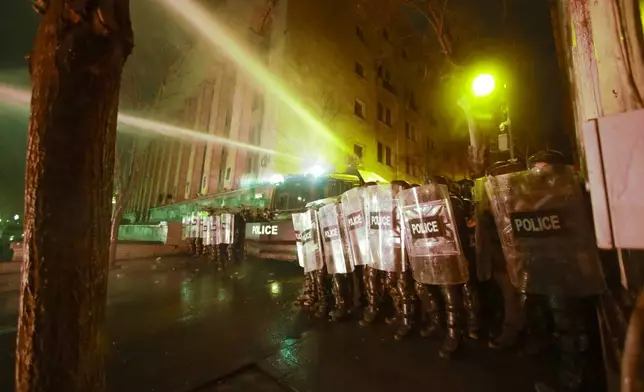 Police use a water cannon to stop protesters rallying outside the parliament's building to continue protests against the government's decision to suspend negotiations on joining the European Union in Tbilisi, Georgia, on Monday, Dec. 2, 2024.(AP Photo/Zurab Tsertsvadze)