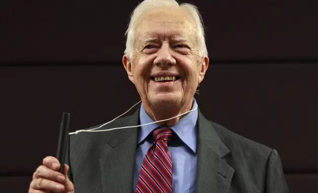 FILE - Former U.S. President Jimmy Carter poses for photographers with a water pipe filter, that is used to combat guinea worm disease, during a news conference to mark the launch of a campaign to eradicate the disease in central London, Wednesday, Oct. 5, 2011. (AP Photo/Lefteris Pitarakis, File)