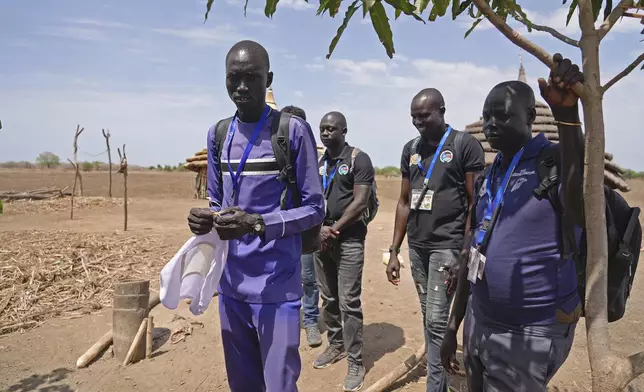 Aid workers with the Carter Center work in the community to raise awareness about Guinea worm and a family impacted in Jarweng, South Sudan, on May 13, 2023. (AP Photo/Sam Mednick)