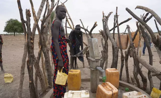 People refill water containers in a community where there was Guinea worm in Jarweng, South Sudan, on May 13, 2023. The Carter Center's staff and volunteers walked house-to-house in the community to raise awareness of the Guinea worm in the area.(AP Photo/Sam Mednick)