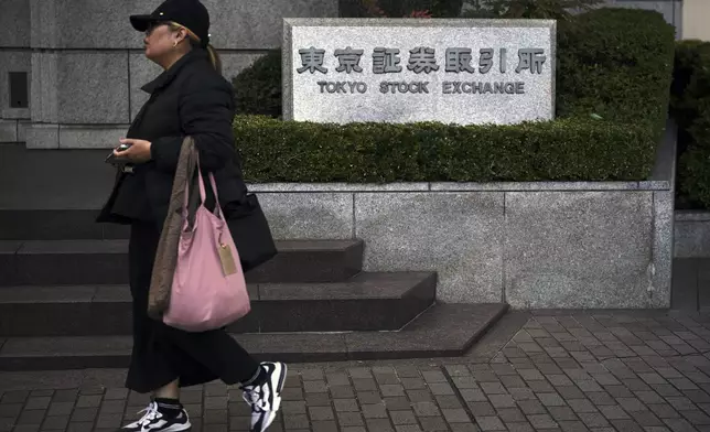 A person walks in front of Tokyo Stock Exchange building Tuesday, Dec. 3, 2024, in Tokyo. (AP Photo/Eugene Hoshiko)