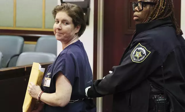 Sarah Boone smiles as she is led off in handcuffs in a courtroom of the Orange County Courthouse in Orlando, Florida, on Monday, Dec. 2, 2024. (Stephen M. Dowell/Orlando Sentinel via AP)