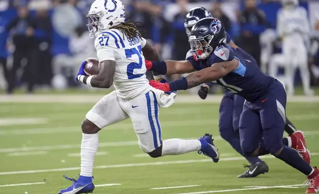 Indianapolis Colts running back Trey Sermon (27) runs the ball past Tennessee Titans linebacker Cedric Gray (51) during the second half of an NFL football game Sunday, Dec. 22, 2024, in Indianapolis. (AP Photo/Michael Conroy)