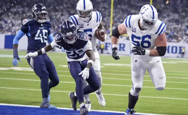 Indianapolis Colts quarterback Anthony Richardson, second from right, runs for a touchdown against the Tennessee Titans cornerback Jarvis Brownlee Jr. (29) and linebacker Arden Key (49) during the first half of an NFL football game Sunday, Dec. 22, 2024, in Indianapolis. (AP Photo/Michael Conroy)