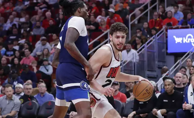 Houston Rockets center Alperen Sengun, right, attempts to drive around Minnesota Timberwolves center Naz Reid, left, during the first half of an NBA basketball game Friday, Dec. 27, 2024, in Houston. (AP Photo/Michael Wyke)