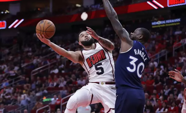 Houston Rockets guard Fred VanVleet (5) lays up a shot against Minnesota Timberwolves forward Julius Randle (30) during the first half of an NBA basketball game Friday, Dec. 27, 2024, in Houston. (AP Photo/Michael Wyke)