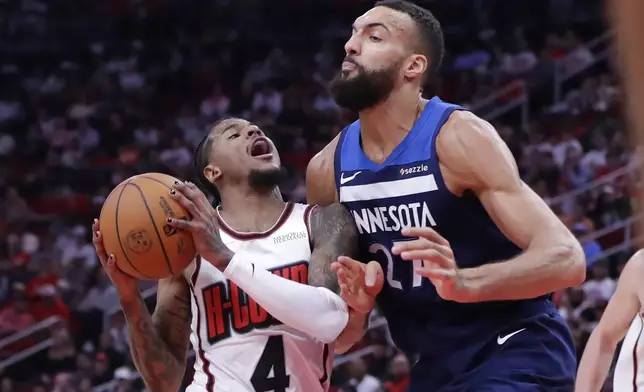 Houston Rockets guard Jalen Green (4) drives to the basket against Minnesota Timberwolves center Rudy Gobert (27) during the first half of an NBA basketball game Friday, Dec. 27, 2024, in Houston. (AP Photo/Michael Wyke)