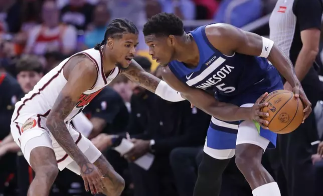 Minnesota Timberwolves guard Anthony Edwards (5) looks to drive around Houston Rockets guard Jalen Green, left, during the first half of an NBA basketball game Friday, Dec. 27, 2024, in Houston. (AP Photo/Michael Wyke)