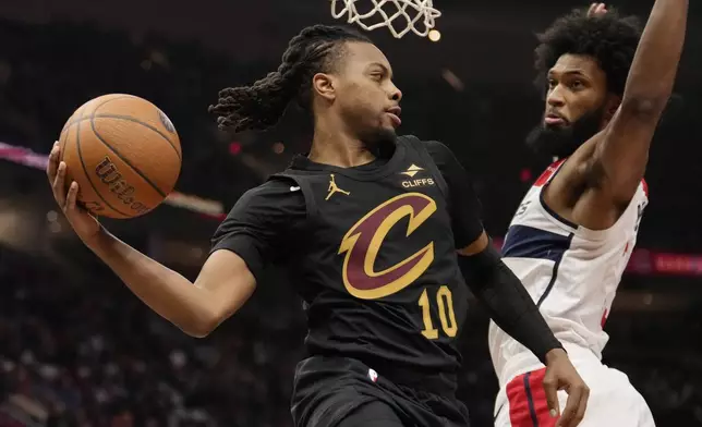 Cleveland Cavaliers guard Darius Garland (10) passes around Washington Wizards forward Marvin Bagley III, right, in the first half of an NBA Cup basketball game, Tuesday, Dec. 3, 2024, in Cleveland. (AP Photo/Sue Ogrocki)