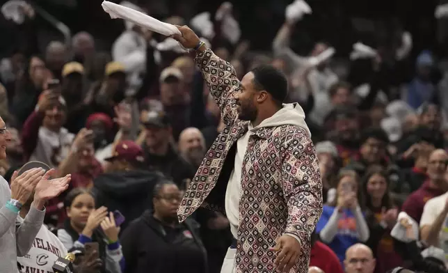 Cleveland Browns defensive end Myles Garrett waves to fans in the first half of an NBA Cup basketball game between the Washington Wizards and the Cleveland Cavaliers, Tuesday, Dec. 3, 2024, in Cleveland. (AP Photo/Sue Ogrocki)