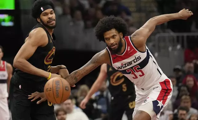 Cleveland Cavaliers center Jarrett Allen, left, and Washington Wizards forward Marvin Bagley III (35) chase a loose ball in the first half of an NBA Cup basketball game, Tuesday, Dec. 3, 2024, in Cleveland. (AP Photo/Sue Ogrocki)