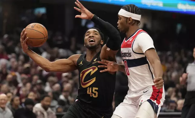 Cleveland Cavaliers guard Donovan Mitchell (45) drives against Washington Wizards' Bilal Coulibaly, right, in the half of an NBA Cup basketball game, Tuesday, Dec. 3, 2024, in Cleveland. (AP Photo/Sue Ogrocki)