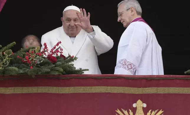 Pope Francis waves before delivering the Urbi et Orbi (Latin for 'to the city and to the world' ) Christmas' day blessing from the main balcony of St. Peter's Basilica at the Vatican, Wednesday, Dec. 25, 2024. (AP Photo/Andrew Medichini)